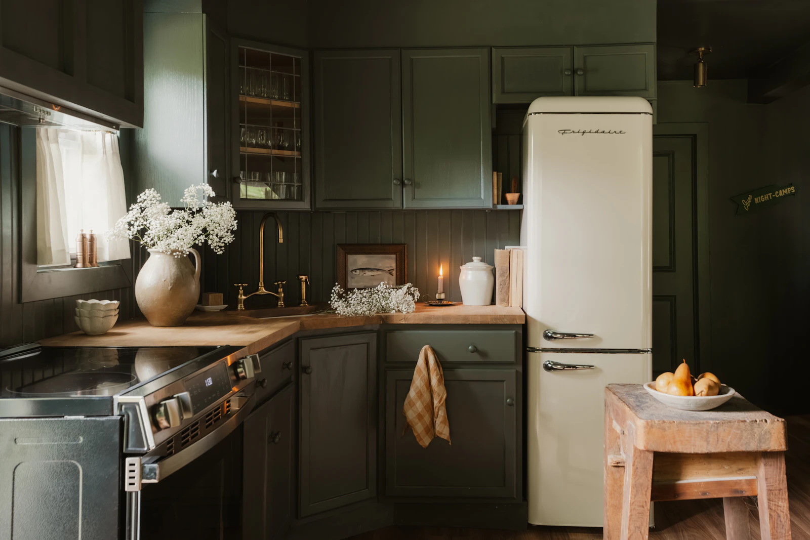Dark green kitchen with brass cabinet hardware